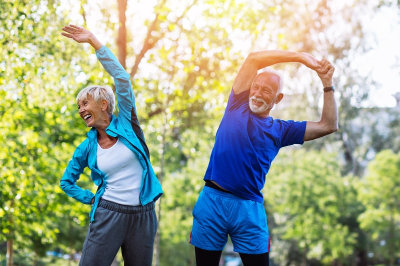 Senior couple stretching in park