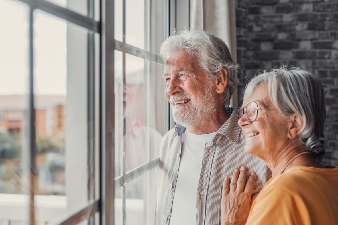 two seniors looking out a window