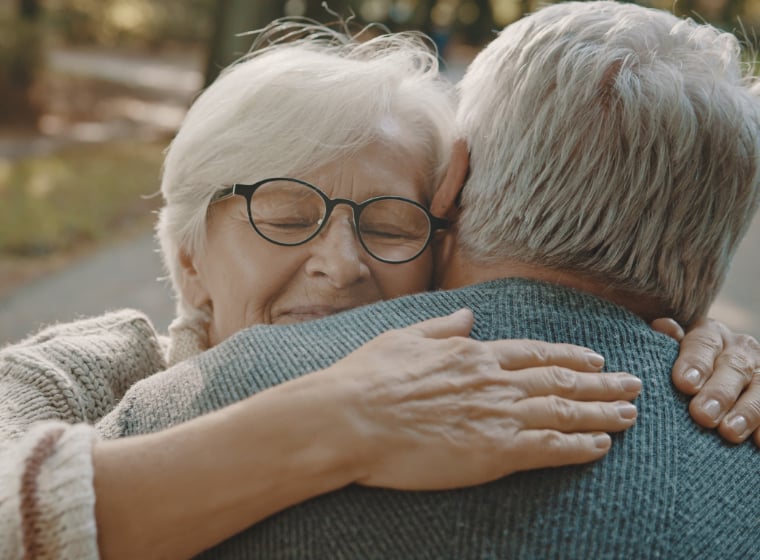 two seniors hugging
