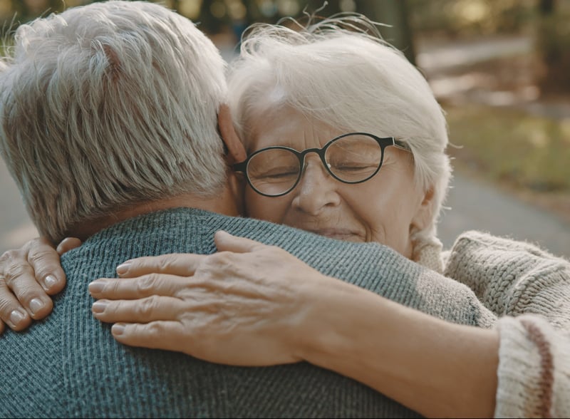 two seniors hugging