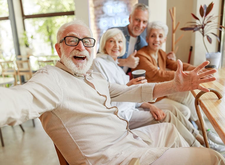 Cheerful old people making selfie in cafe