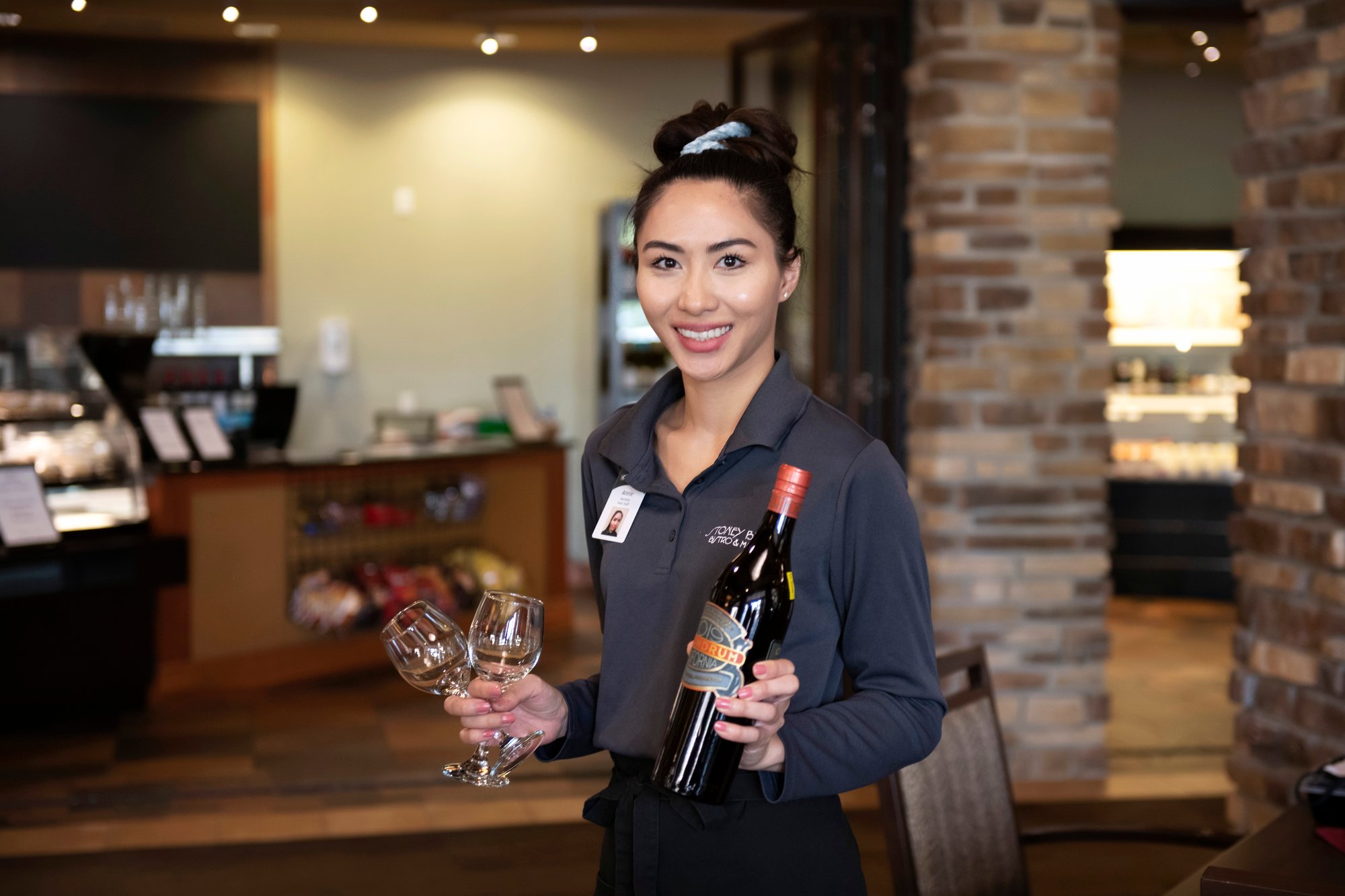 waitress smiling with wine glasses