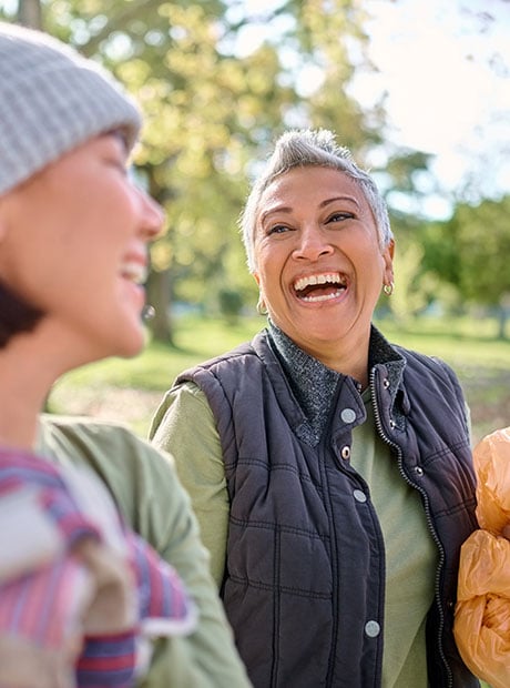 Two friends laughing in a park together.