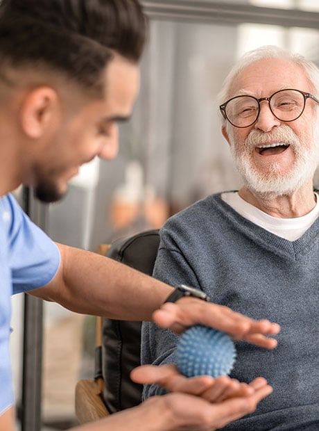 Patient having his hand massaged with a spiky massage ball