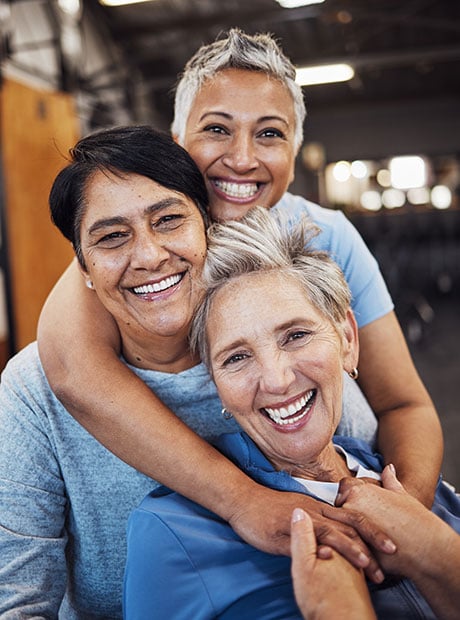 Elderly friends hugging each other.