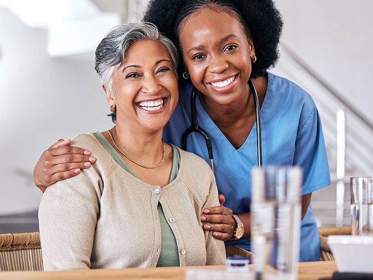 Assisted living resident and caregiver smiling together