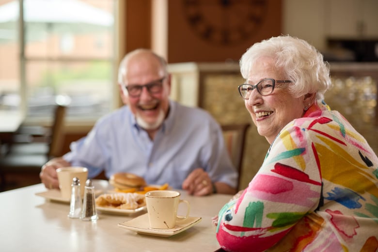 Laughing older couple having fun over lunch