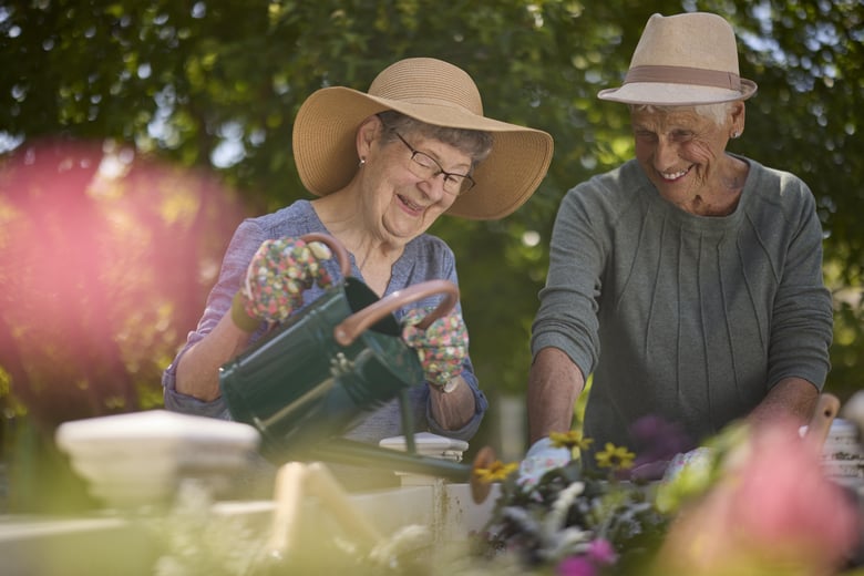 Friends gardening with smiles on their faces