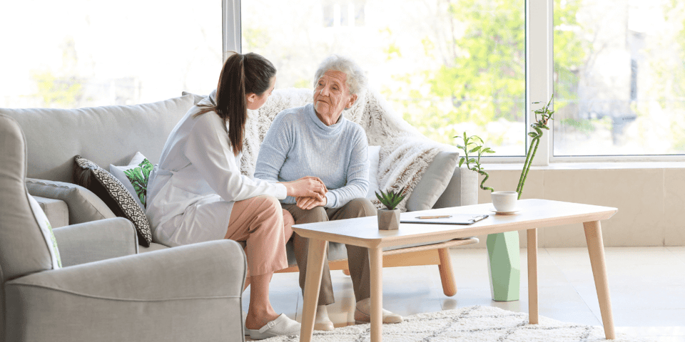 A doctor with an older woman in a comfortable living space