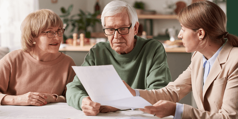 Senior couple sitting at the table and discussing documents