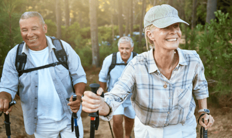 Two men and a woman hiking outdoors.